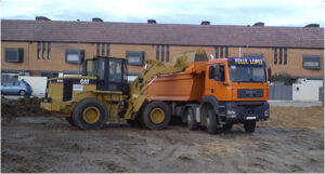 Servicios de movimiento de tierras y transporte de materiales por excavaciones Félix López en obra pública. La escena refleja el compromiso de excavaciones Félix López con la eficiencia, aportando cargadoras CAT y vehículos especializados para proyectos de construcción y obras públicas.​
