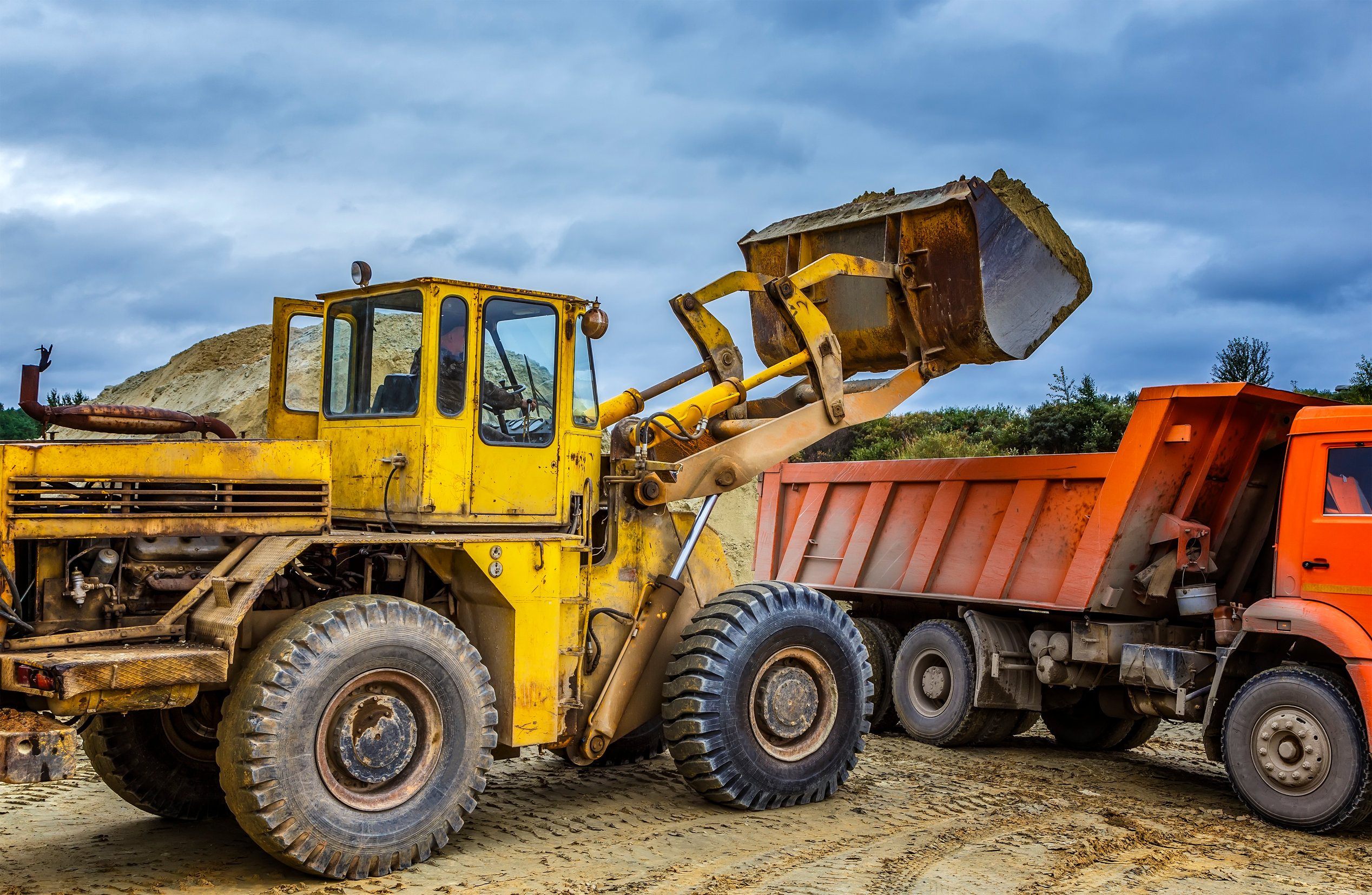 Cargadora de excavaciones Félix López llenando camión con material en obra civil. Esta imagen representa la eficacia en servicios de carga, transporte de tierras y gestión de materiales que ofrece excavaciones Félix López para proyectos de construcción e infraestructura en Salamanca y Castilla y León